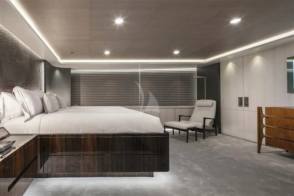 a bedroom with a bed and a chair aboard REVERIE Yacht for Sale