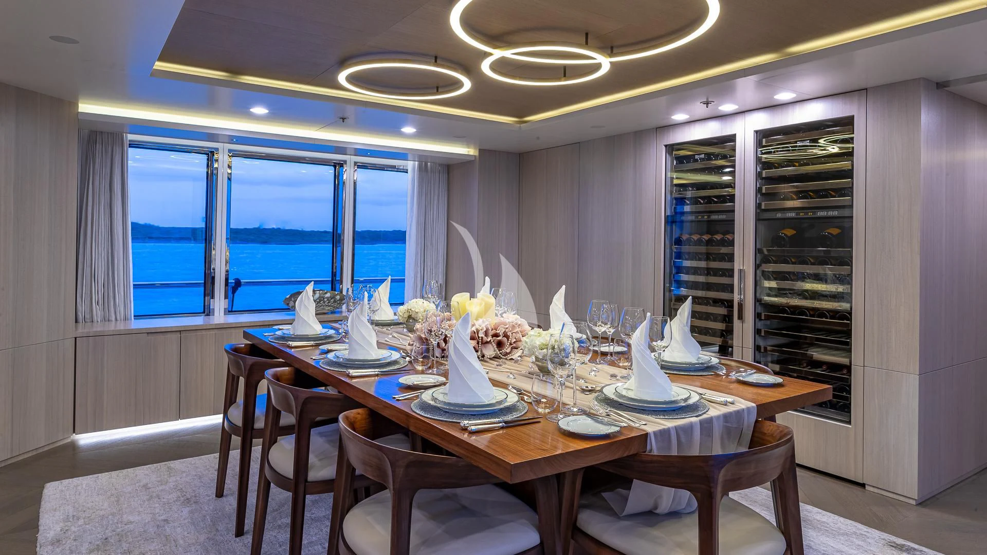 a dining table with plates and flowers aboard REVERIE Yacht for Sale