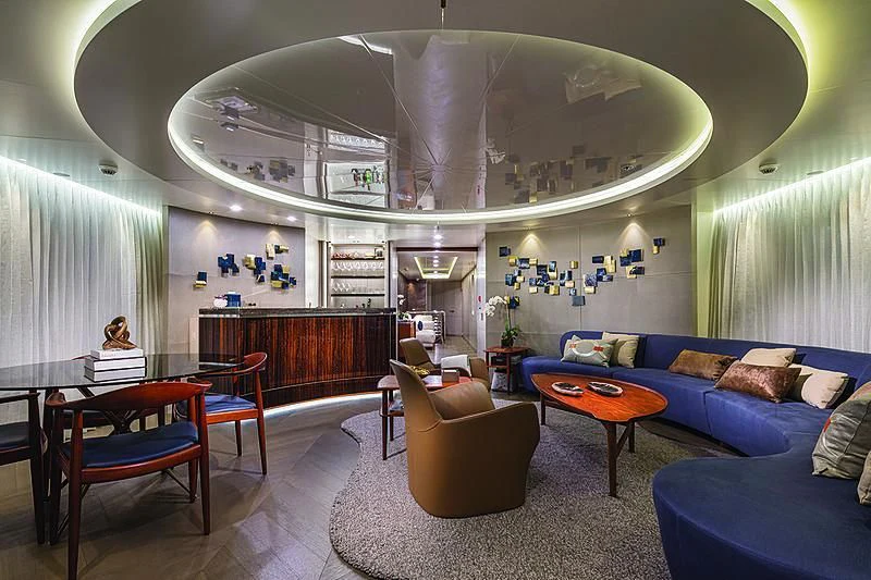 a room with a blue couch and a large mirror aboard REVERIE Yacht for Sale