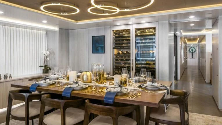 a dining room with a table set for a meal aboard REVERIE Yacht for Sale