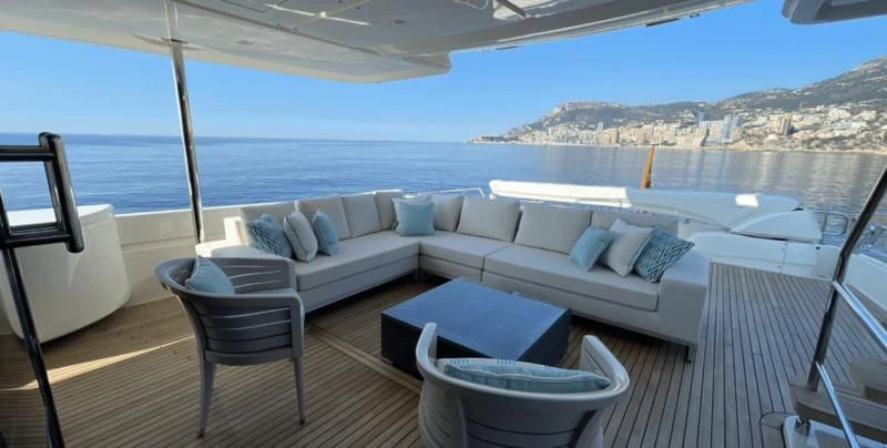 a large white lounge chair on a deck overlooking a large body of water aboard CENTURION Yacht for Sale