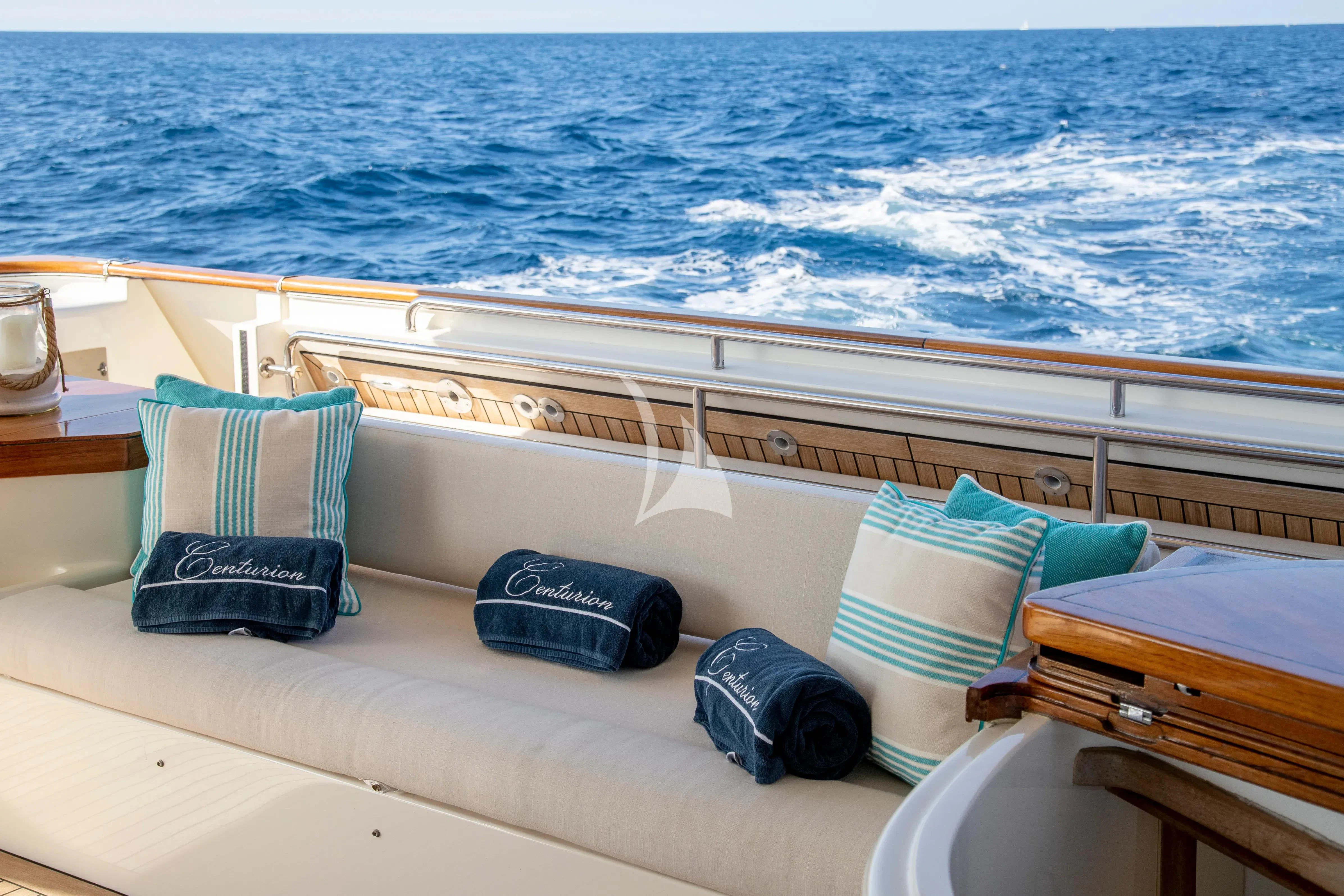 a boat with blue and white striped pillows on the deck aboard CENTURION Yacht for Sale