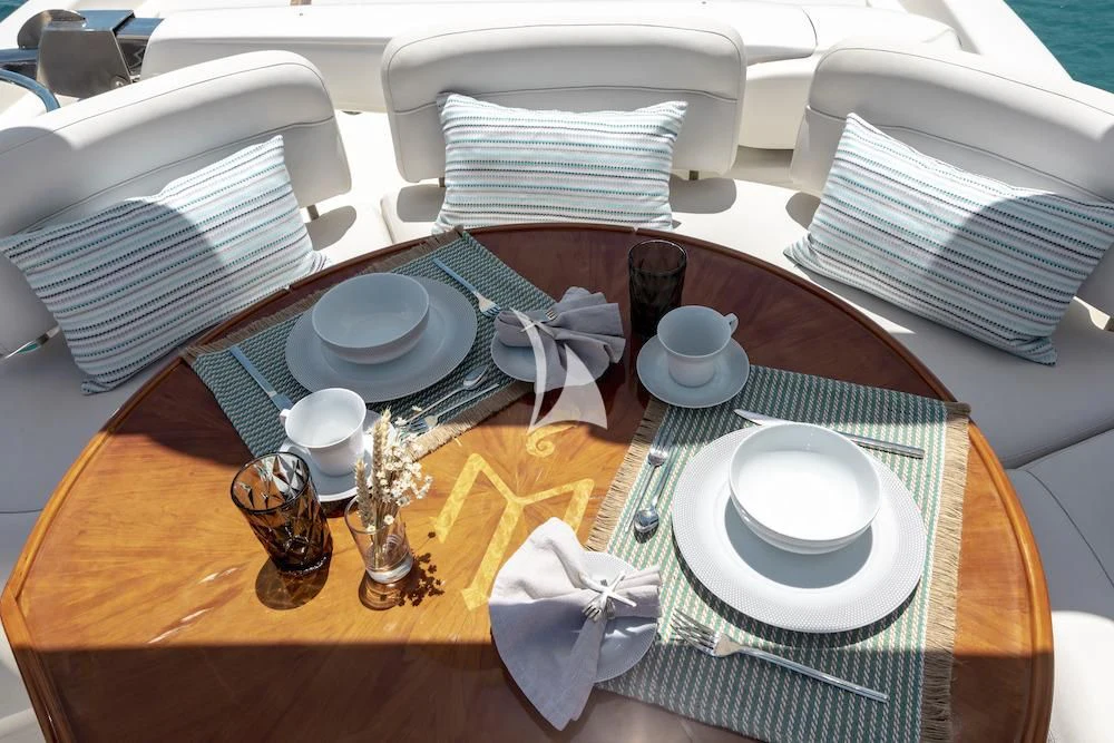 a table with plates and cups on it aboard MANU Yacht for Charter
