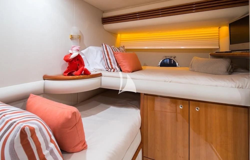 a bedroom with a bed and a television aboard MANU Yacht for Charter