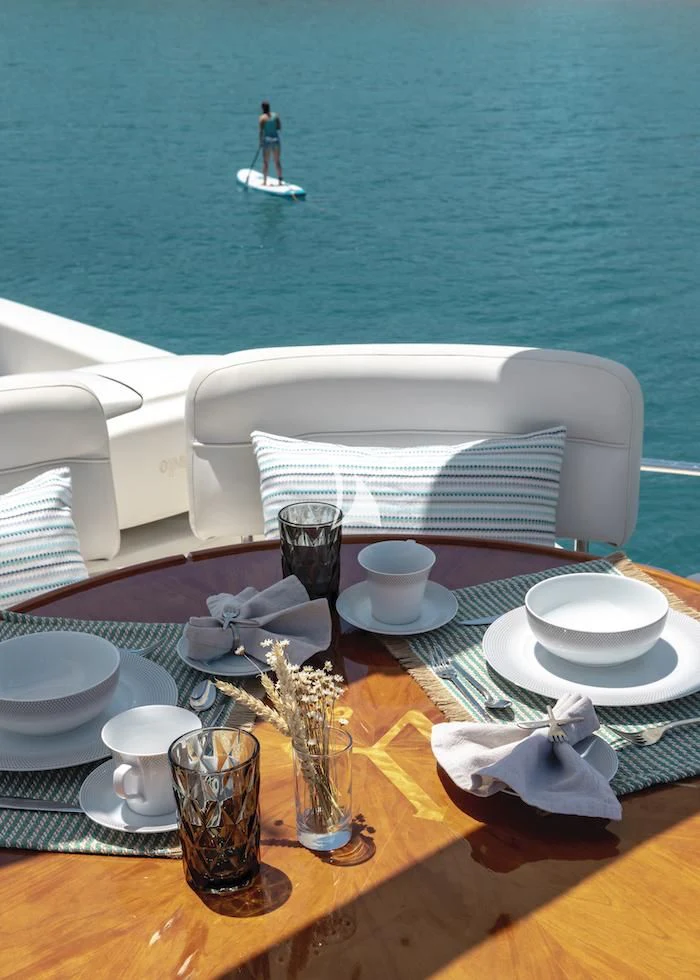 a table with a chair and a table with food on it aboard MANU Yacht for Charter