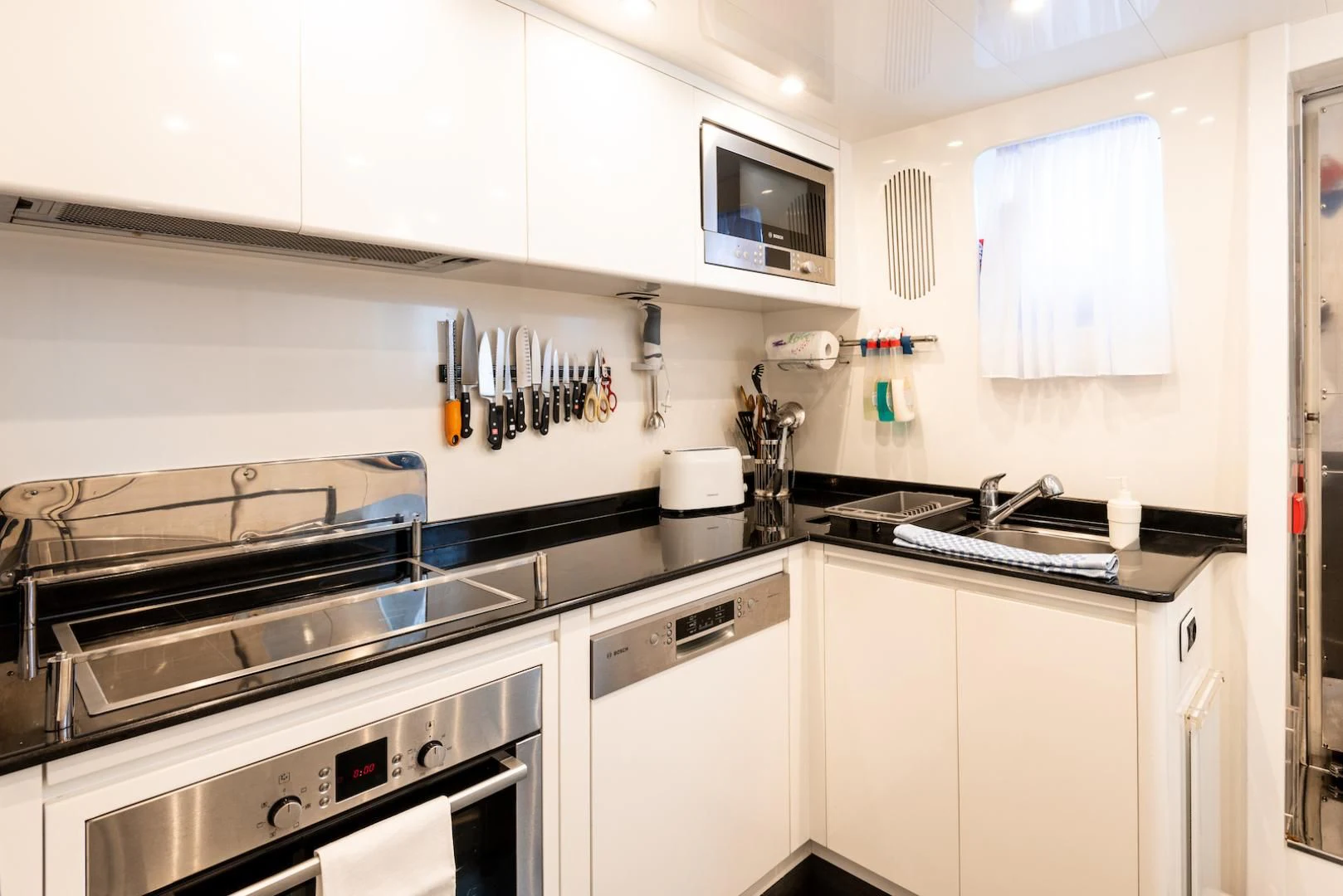 a kitchen with white cabinets aboard ALPINN Yacht for Sale