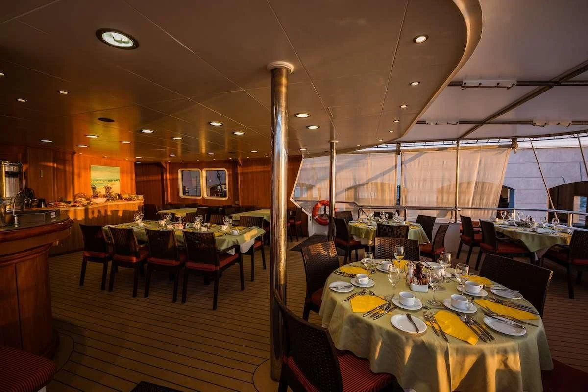 a restaurant with tables and chairs aboard PAN ORAMA II Yacht for Sale