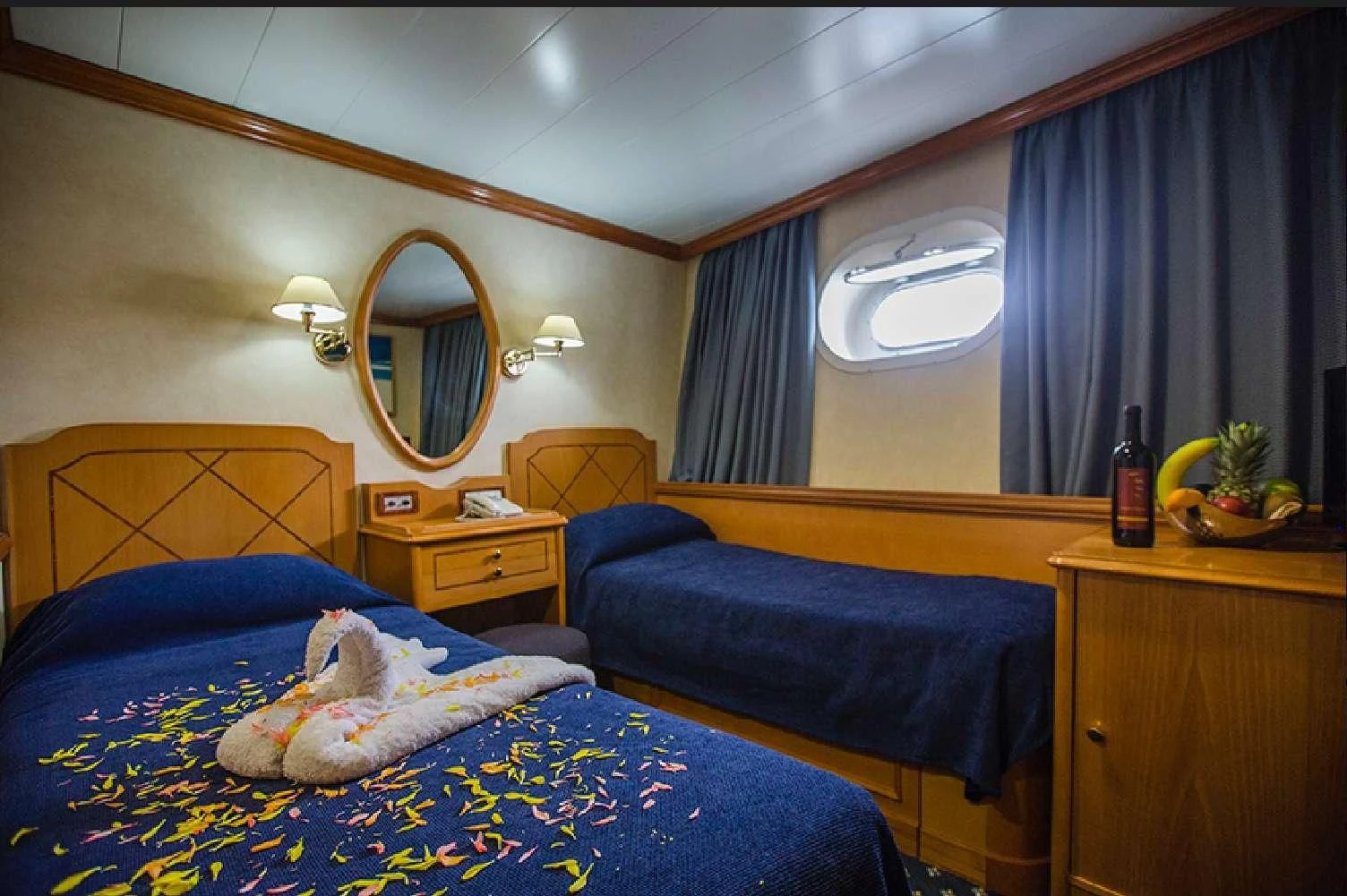 a bedroom with a bed and a mirror aboard PAN ORAMA II Yacht for Sale