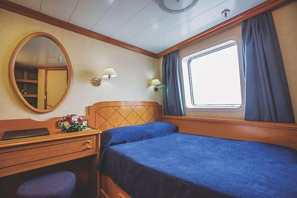 a bedroom with a mirror and a bed aboard PAN ORAMA II Yacht for Sale
