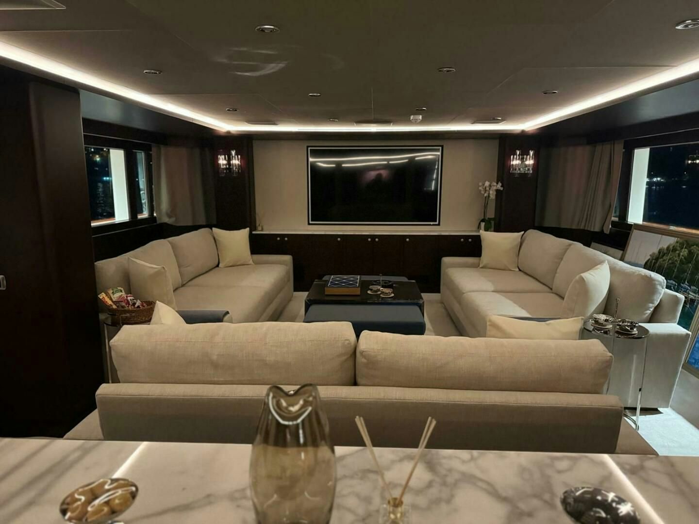 a living room with a large screen aboard KORU Yacht for Charter