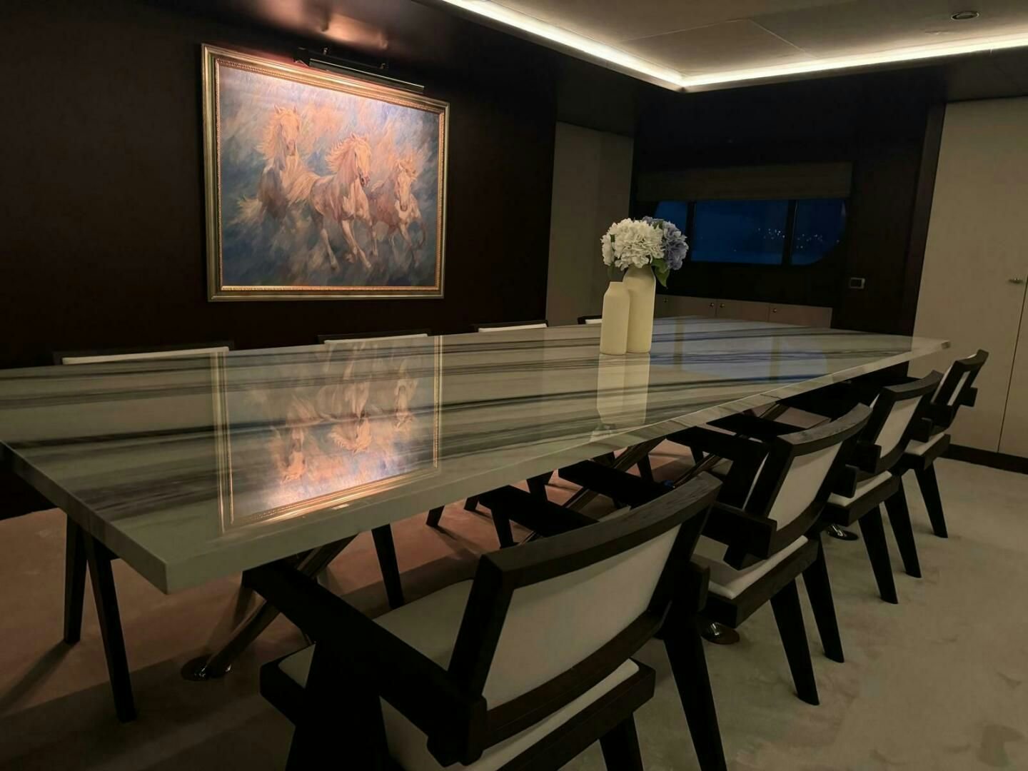 a table with chairs and a vase of flowers on it aboard KORU Yacht for Charter