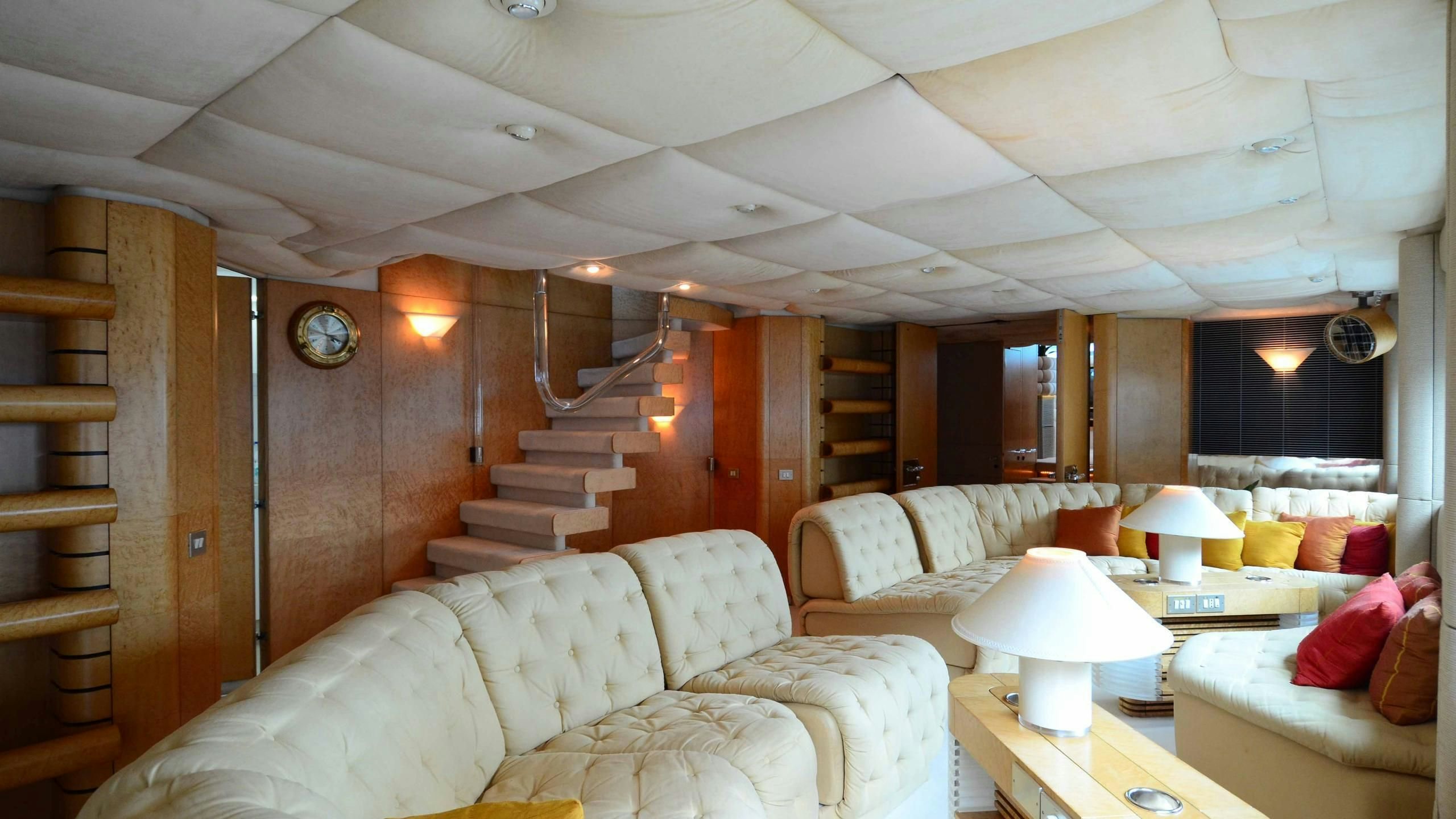 a living room with a staircase and couches aboard KORU Yacht for Charter