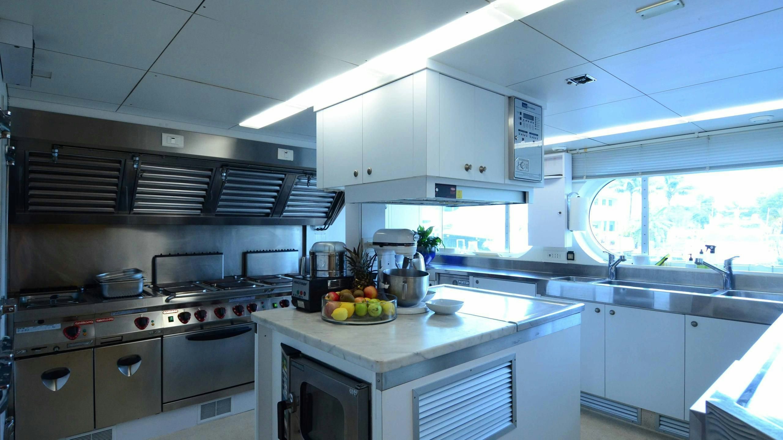 a kitchen with white cabinets aboard KORU Yacht for Charter