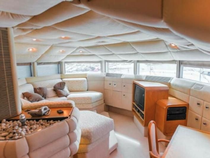 a room with a couch and a television aboard KORU Yacht for Charter