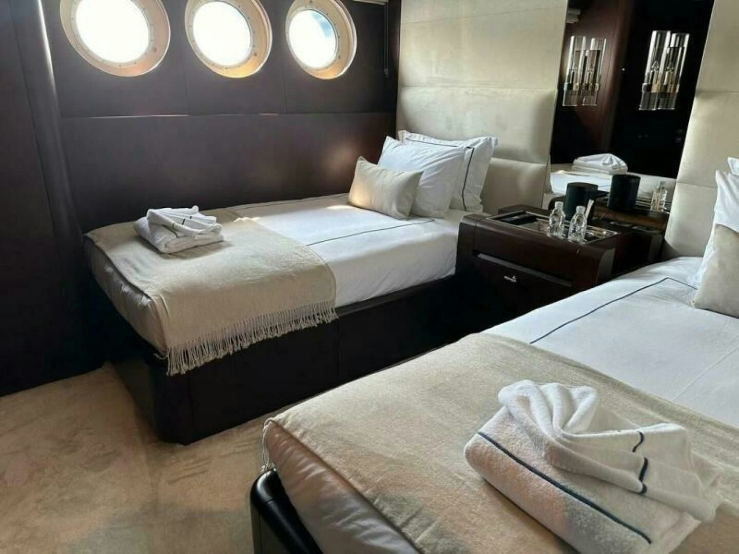 a couple of beds in a hotel room aboard KORU Yacht for Charter
