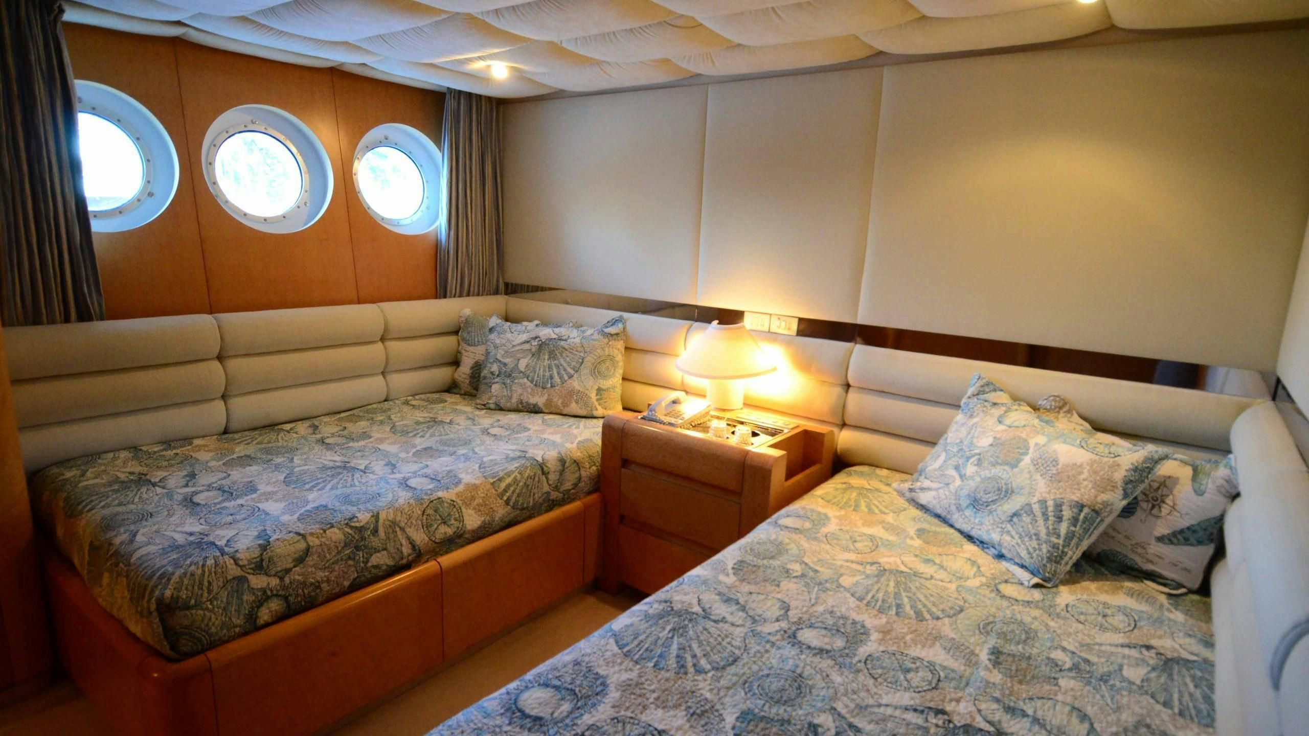 a couple of beds in a hotel room aboard KORU Yacht for Charter