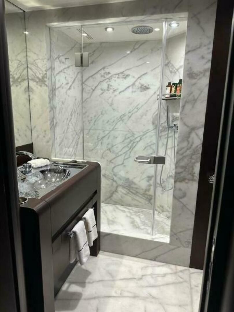 a bathroom with a glass shower aboard KORU Yacht for Charter