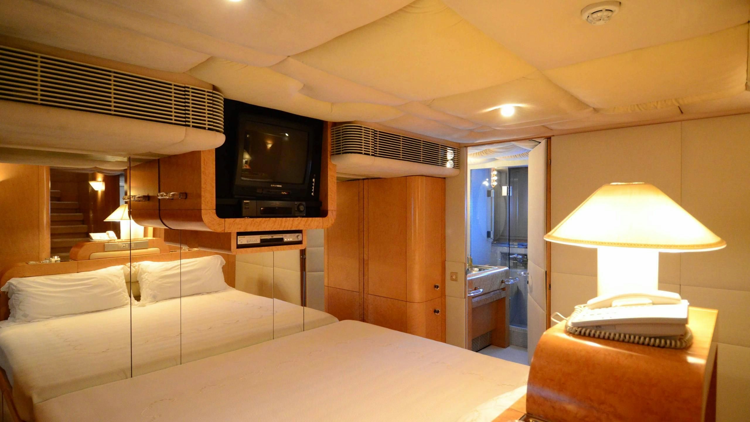 a hotel room with a bed and tv aboard KORU Yacht for Charter