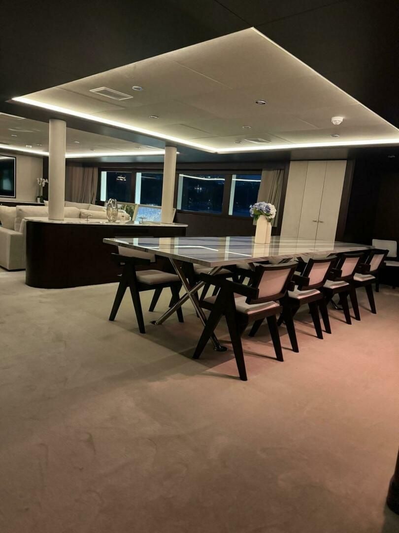 a room with tables and chairs aboard KORU Yacht for Charter