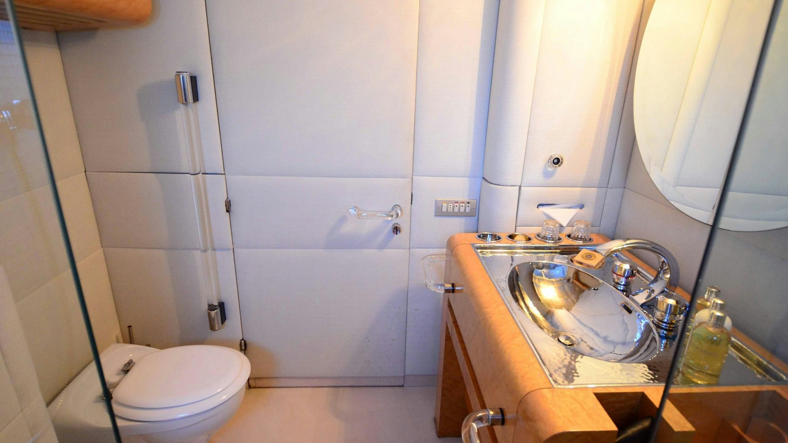 a bathroom with a sink toilet and a mirror aboard KORU Yacht for Charter