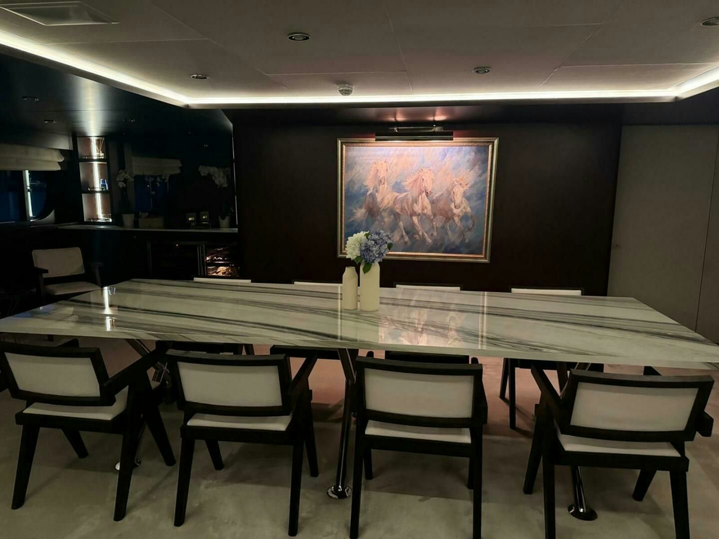 a table with chairs and a vase with flowers on it aboard KORU Yacht for Charter