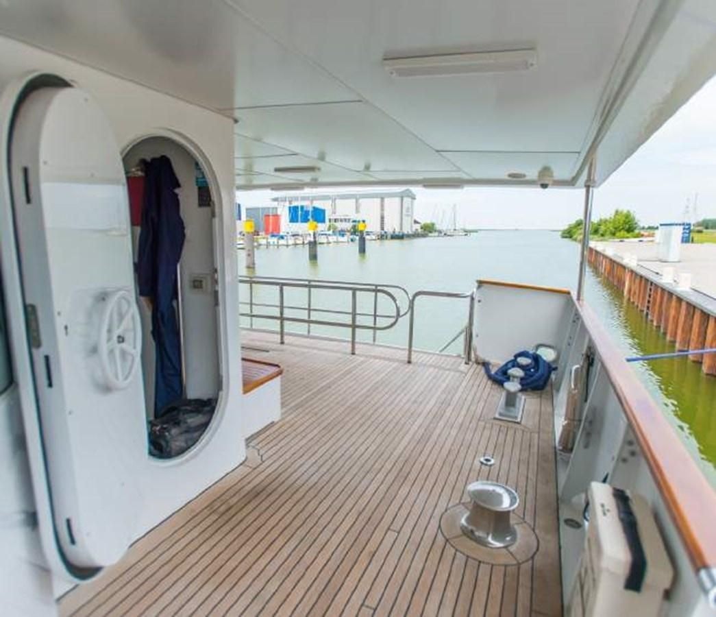 a long hallway with a door and a railing and a pool aboard KORU Yacht for Charter