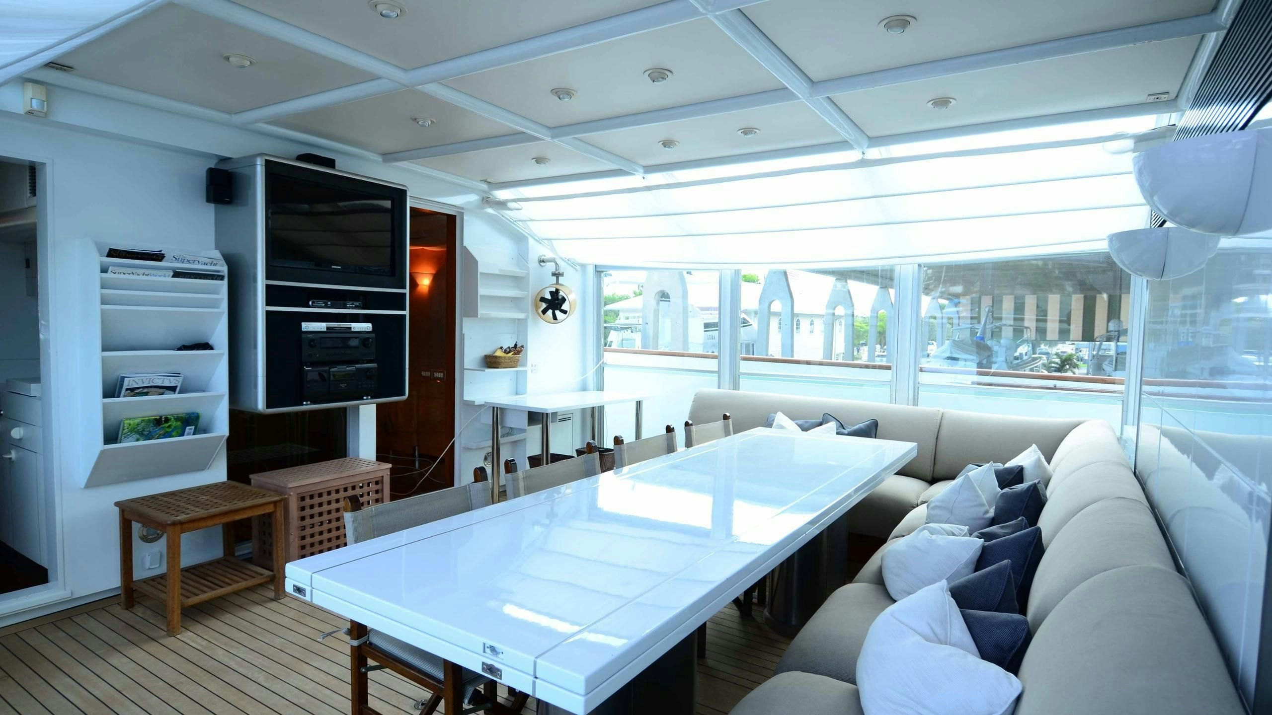 a living room with a large table and a tv aboard KORU Yacht for Charter