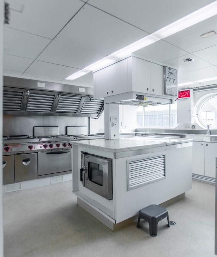 a kitchen with white cabinets aboard KORU Yacht for Charter
