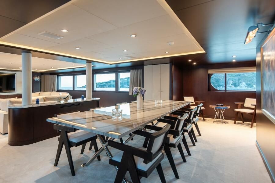 a large room with tables and chairs aboard KORU Yacht for Charter