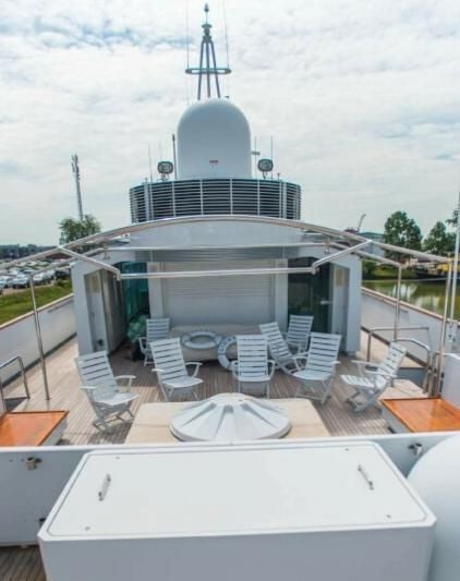 a deck with chairs and a table on it aboard KORU Yacht for Charter