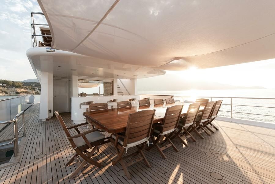 a large dining room with a large deck and a large patio with a view of the ocean and aboard KORU Yacht for Charter