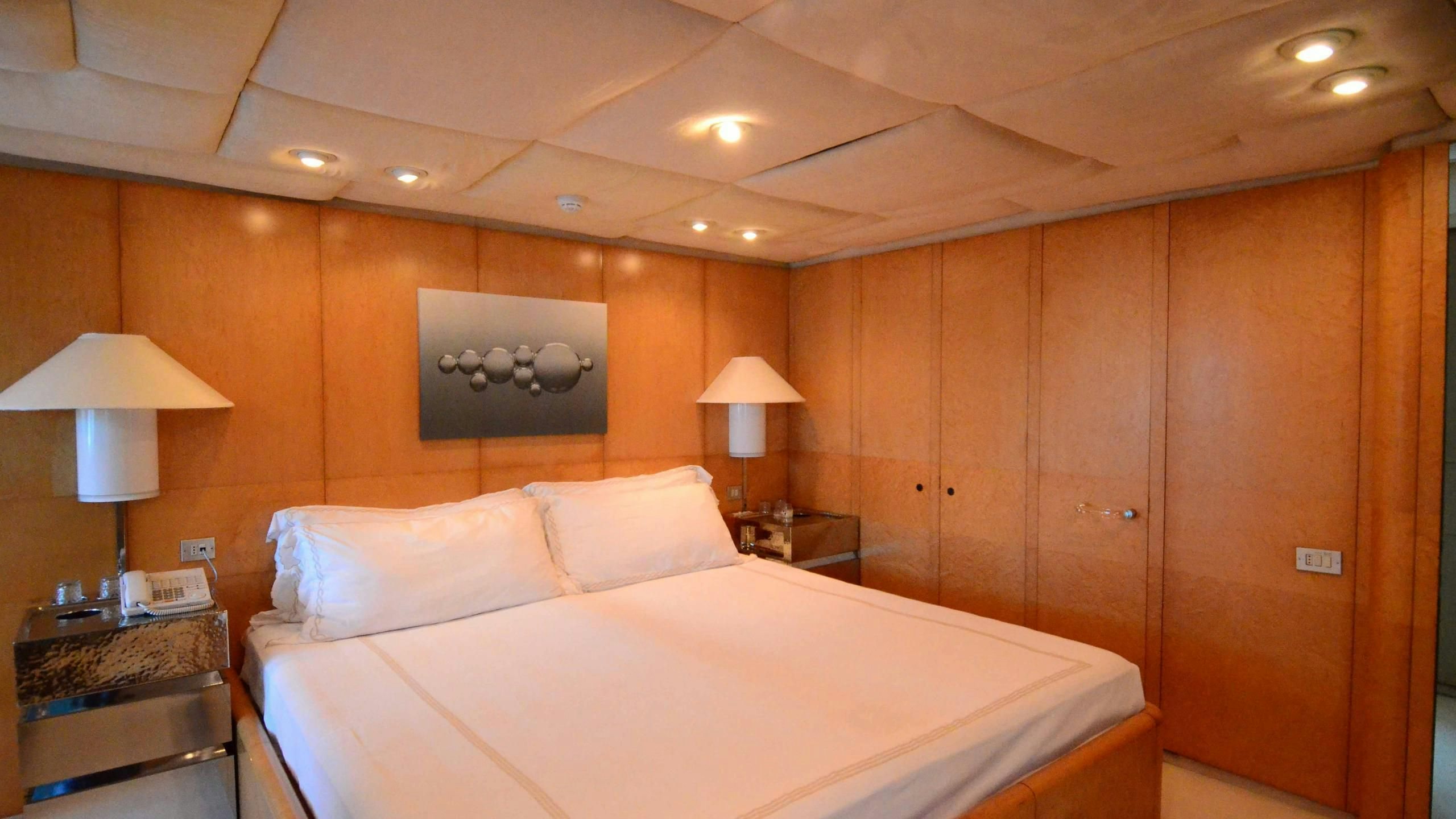 a room with a bed and a lamp aboard KORU Yacht for Charter
