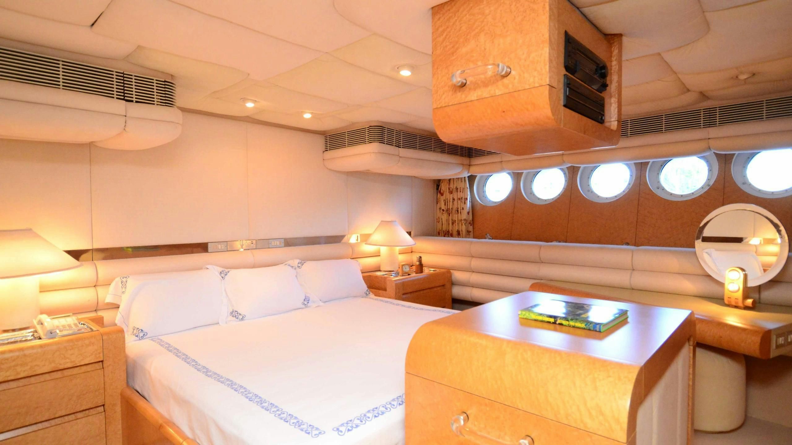 a room with a bed and a desk aboard KORU Yacht for Charter