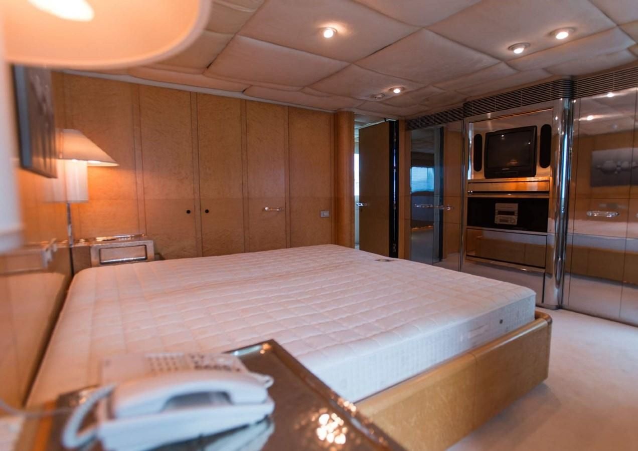 a hotel room with a bed and a television aboard KORU Yacht for Charter