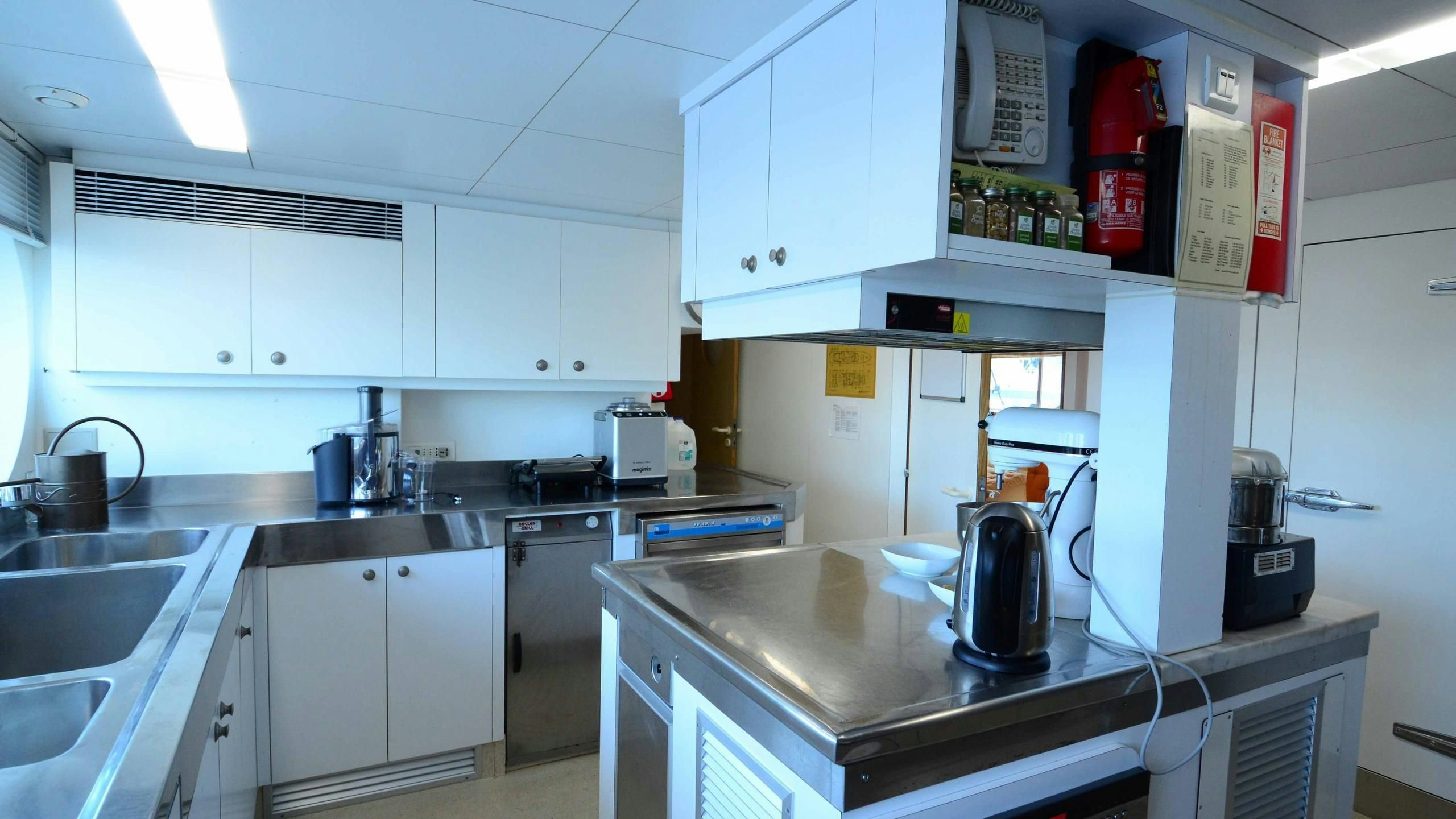 a kitchen with white cabinets aboard KORU Yacht for Charter