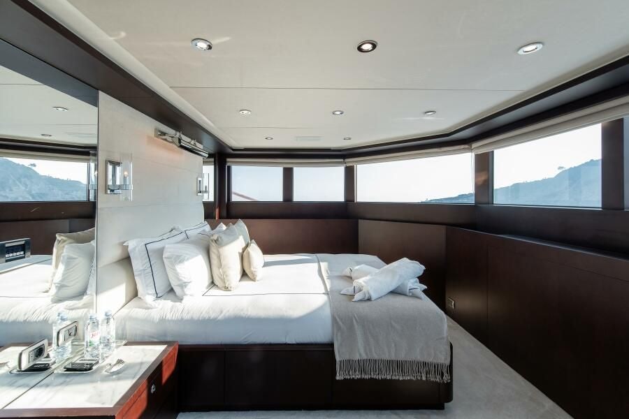 a room with a bed and a table aboard KORU Yacht for Charter