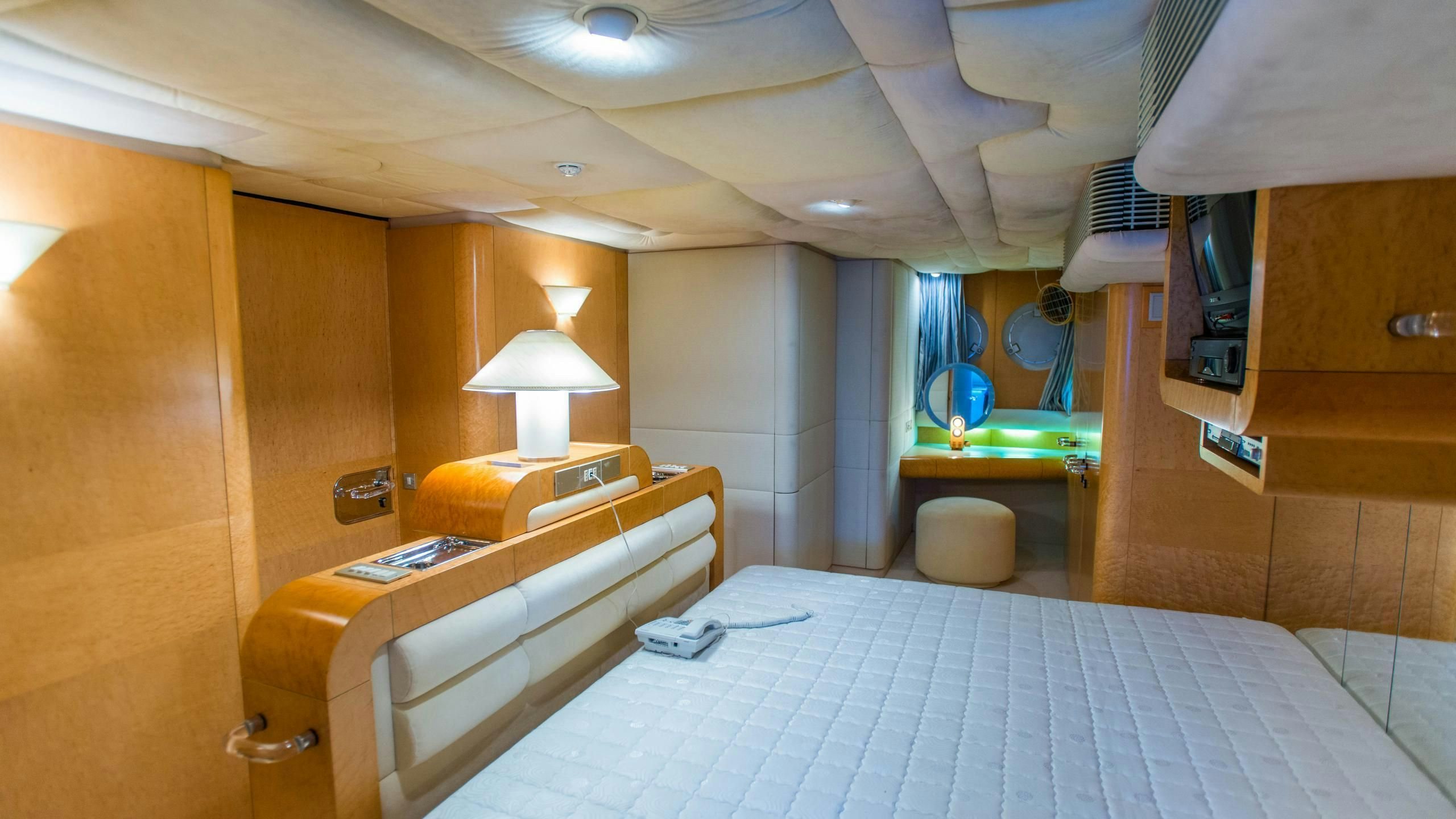 a room with a bed and a desk aboard KORU Yacht for Charter