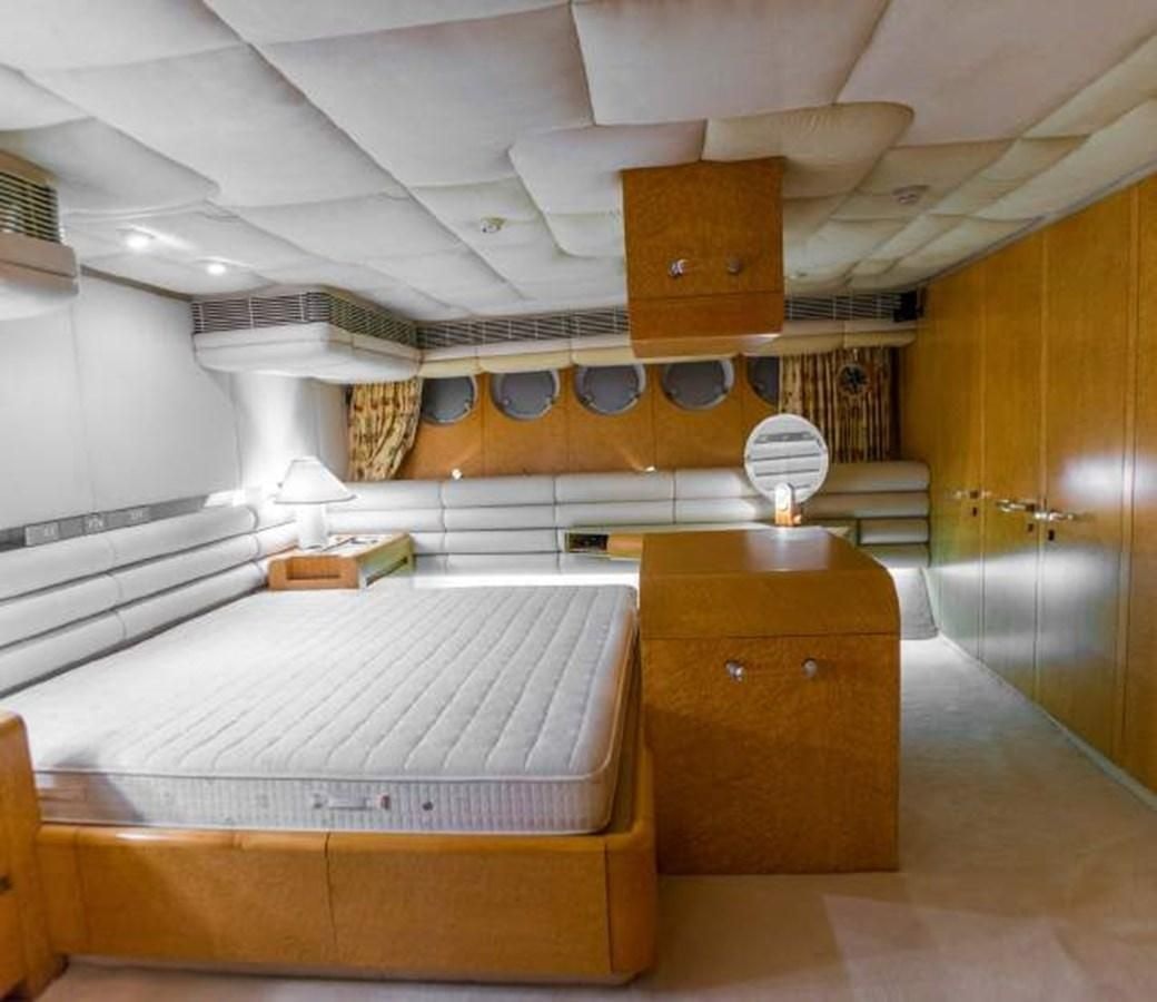a room with a bed and a fan aboard KORU Yacht for Charter