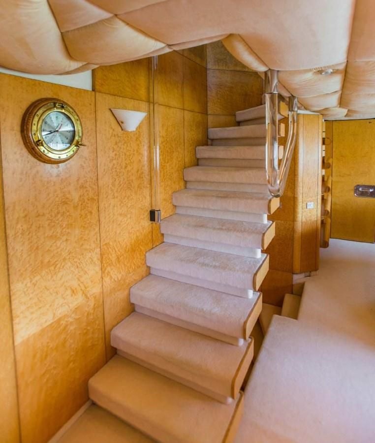 a staircase with a clock on the side aboard KORU Yacht for Charter