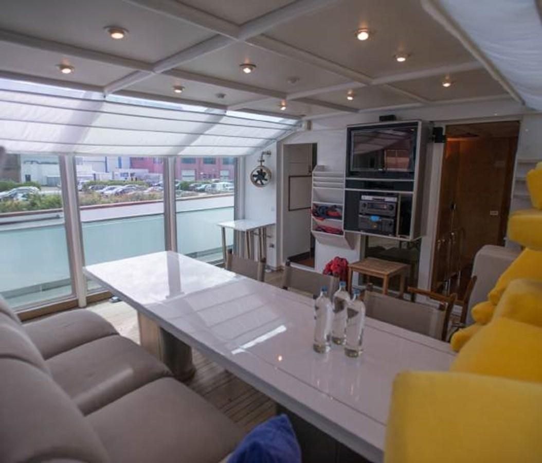 inside of a vehicle with tables and chairs and a large window aboard KORU Yacht for Charter