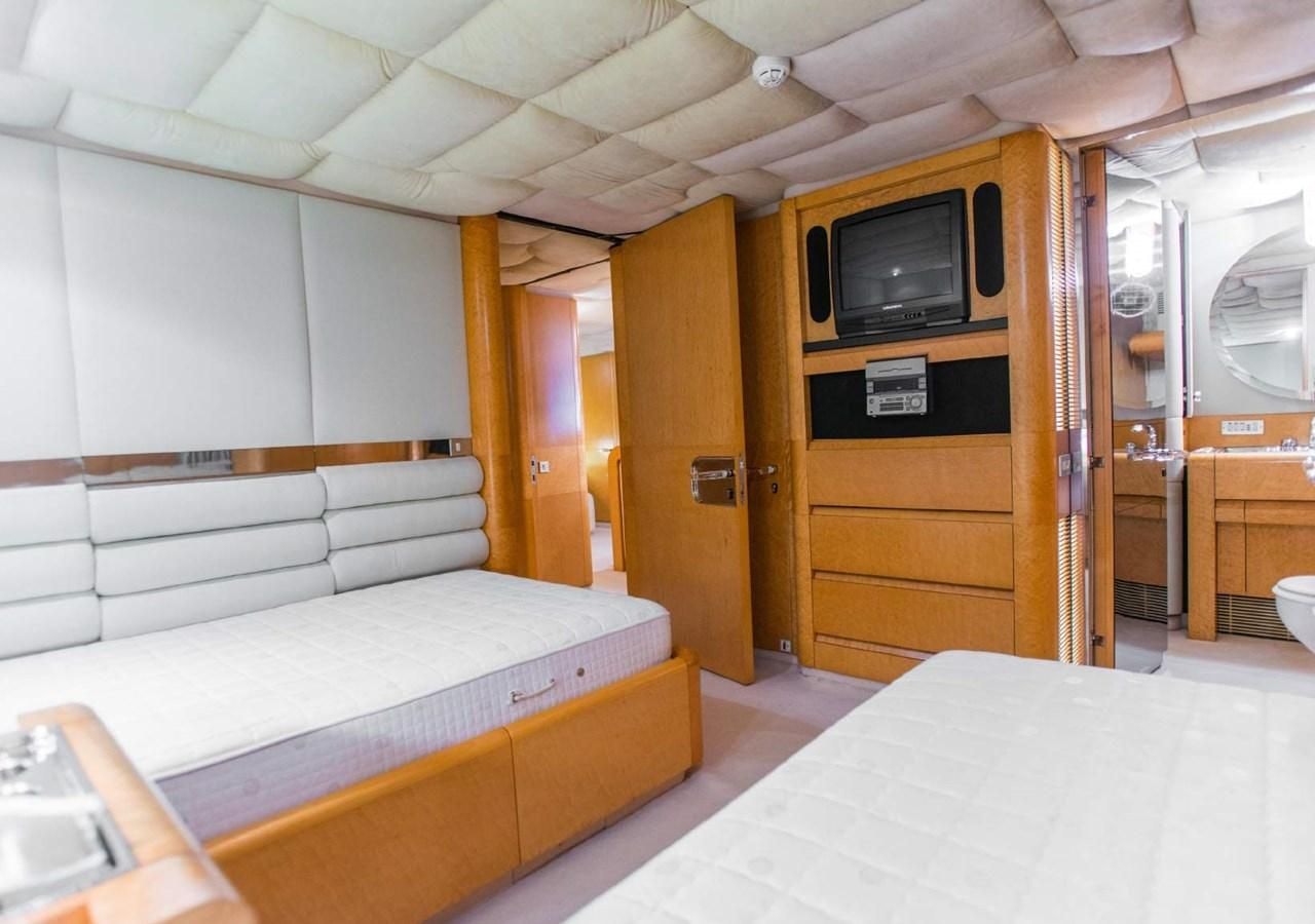 a room with a bed and a tv aboard KORU Yacht for Charter