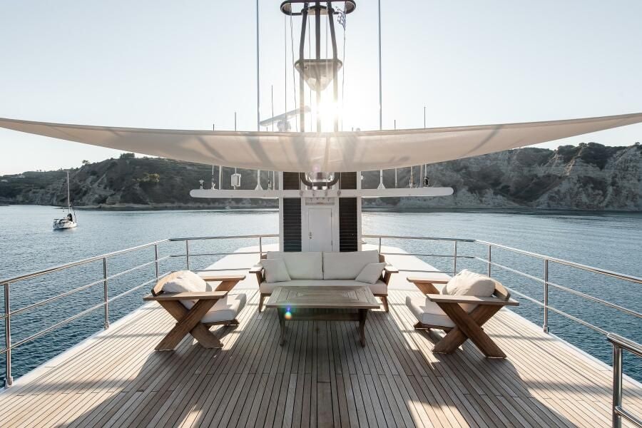 a deck with chairs and a body of water and a bridge aboard KORU Yacht for Charter