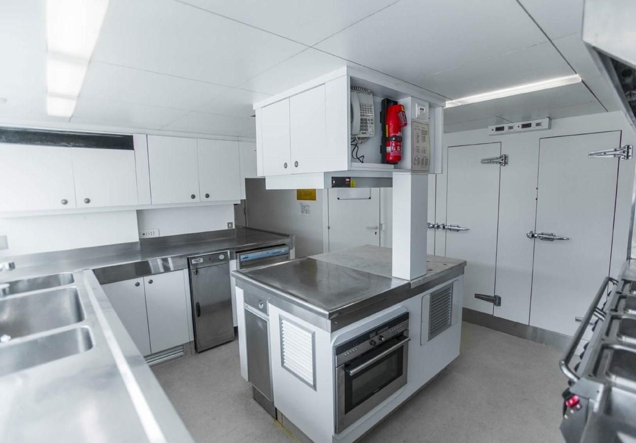 a kitchen with white cabinets aboard KORU Yacht for Charter