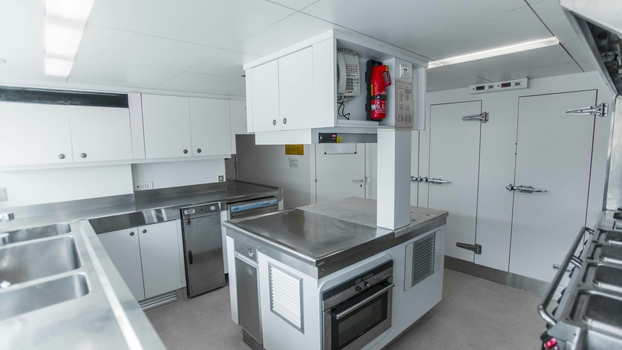 a kitchen with white cabinets aboard KORU Yacht for Charter