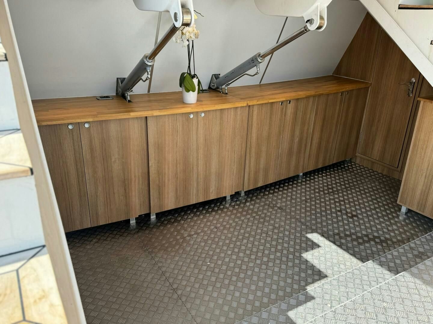 a wood cabinet with a shelf and a lamp on it aboard KORU Yacht for Charter