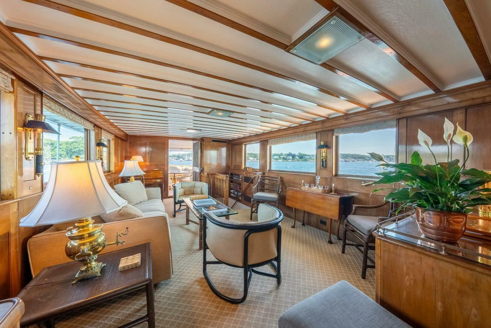 a room with a table chairs and plants in it aboard BERNADETTE Yacht for Sale