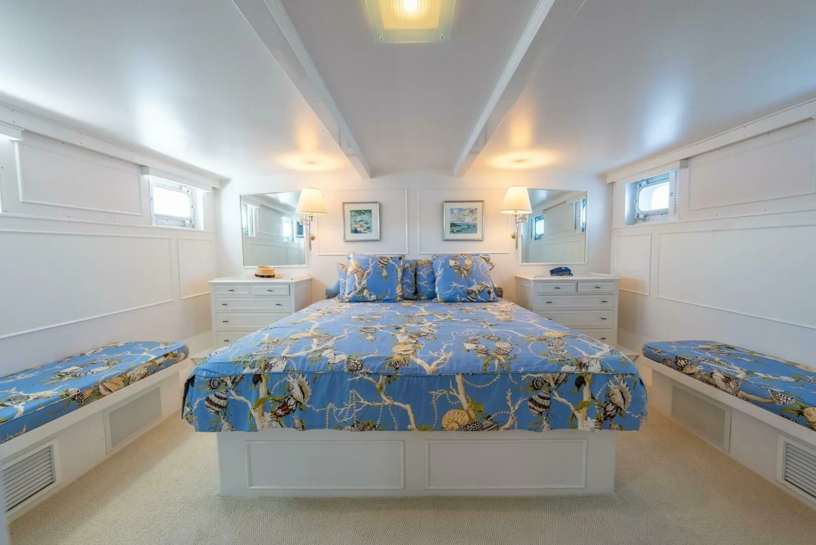 a bedroom with a bed and a blue bed spread aboard BERNADETTE Yacht for Sale