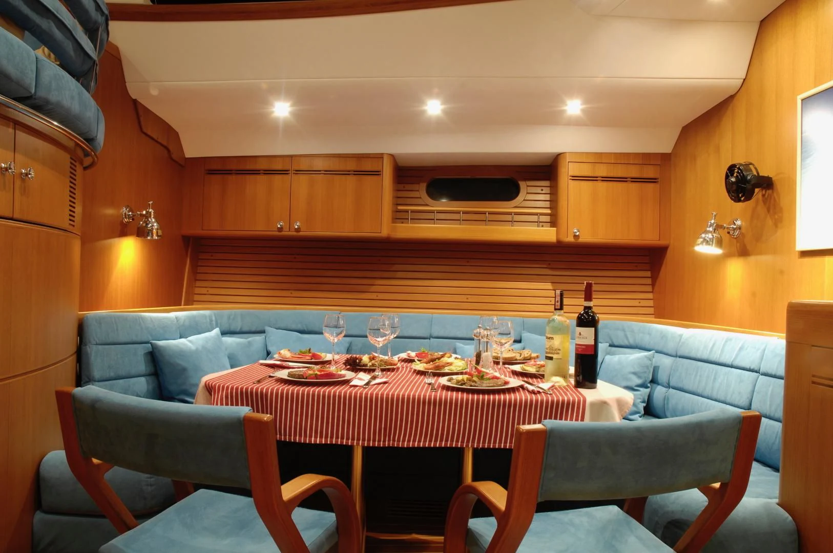 a dining table and chairs in a room with wood cabinets aboard PULSAR II Yacht for Sale