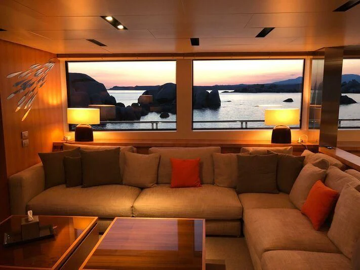 a couch and a table in a room with a large window aboard ST. BARTH Yacht for Sale