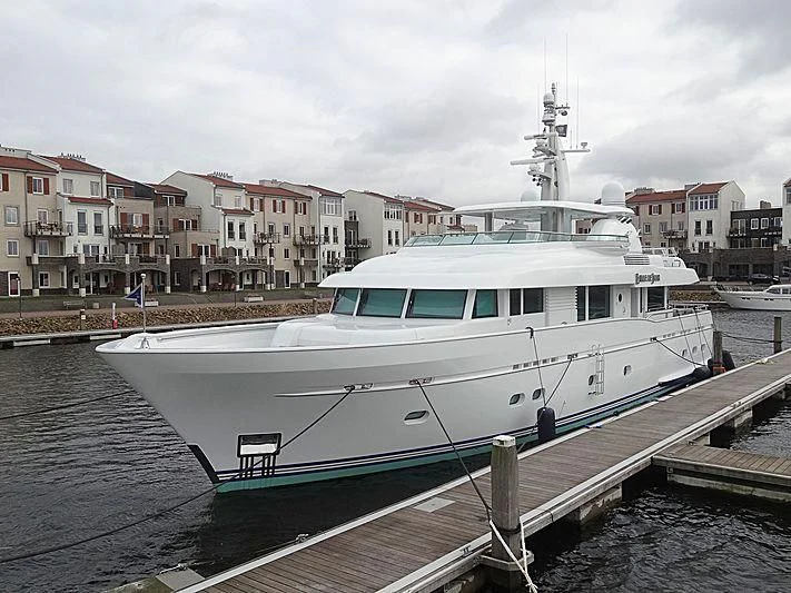 a large white boat in a harbor aboard BELLE DE JOUR Yacht for Sale